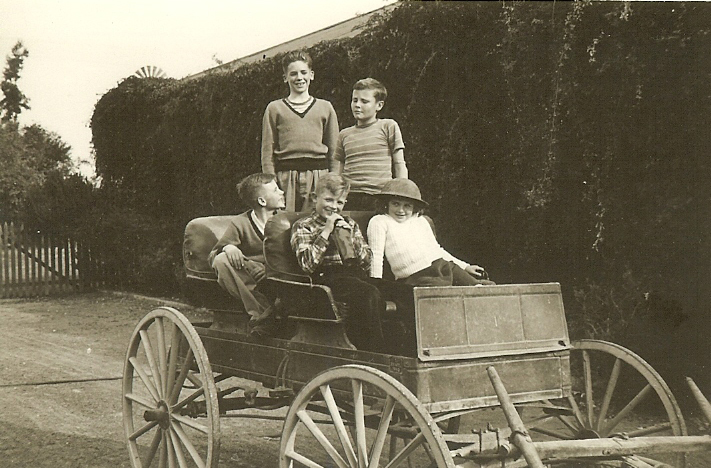 CJ II, Michael, Peter, Susan and a neighbor pose for a photo on an antique wagon.
