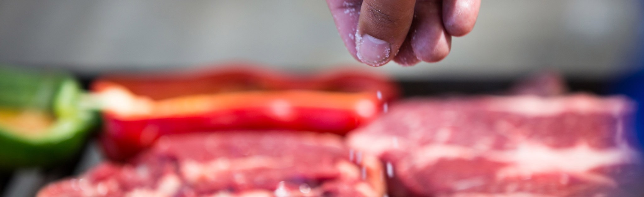 Steaks and bell peppers on the grill during a winery asado.