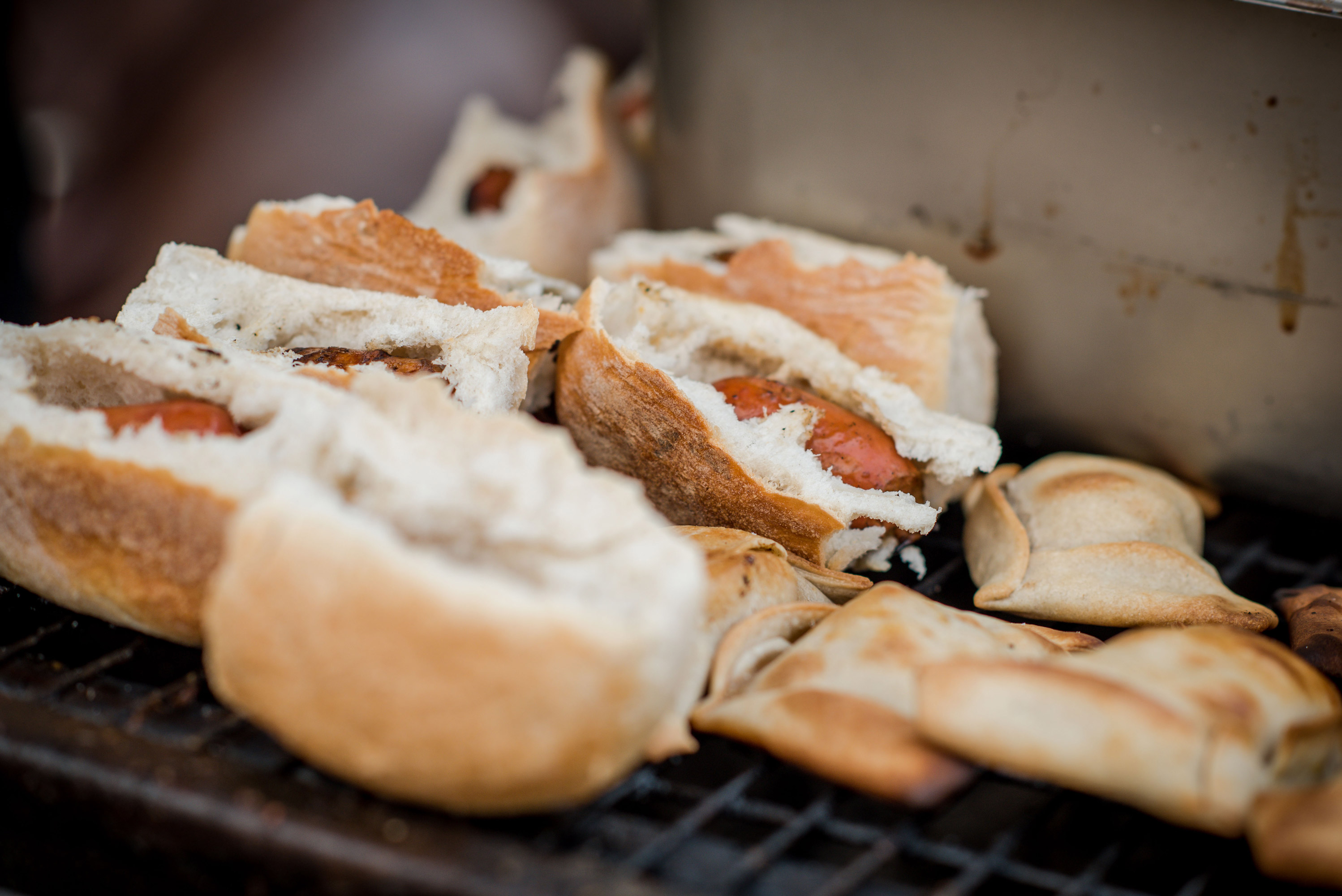 Choripan or bread and chorizo alongside some empanadas on the grill for a barbecue at the winery.