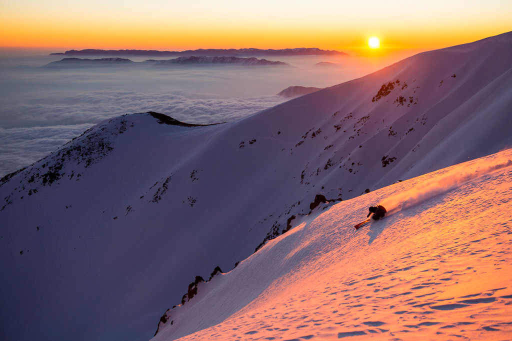 The sun sets as a skier gets in the last run of the day. Photo by Michael Neumann, courtesy of Upscape Travel.