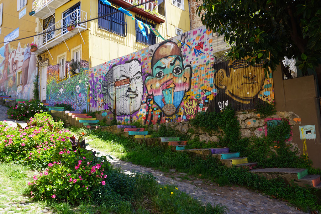 Colorful murals cover a city wall and staircase. Photo by Robert Goldberg.